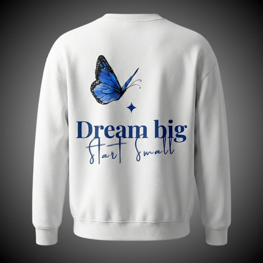 Achterkant van een witte trui met een opdruk van een grote blauwe vlinder en de motiverende tekst 'Dream big Start small'.